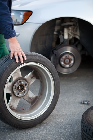 mechanic changing a wheel of a modern car (color toned image)の写真素材