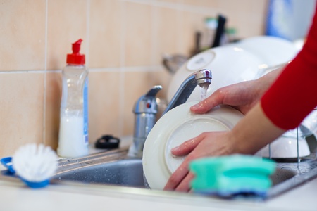Washing of the dishes - woman hands rinsing dishes under running water in the sinkの写真素材