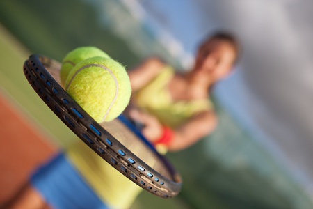 pretty, young female tennis player on the tennis court (shallow DOF, selective focus)の写真素材