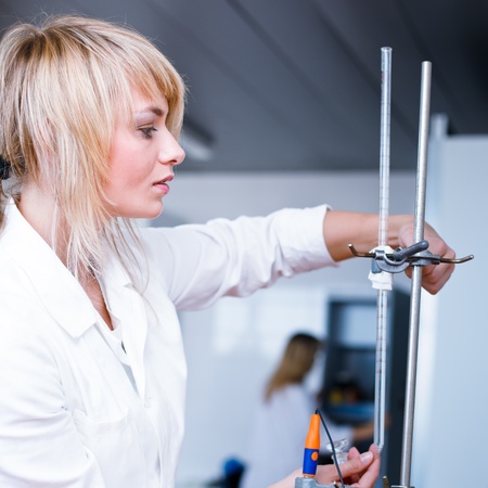 Closeup of a female researcher/chemistry student carrying out experiments in a lab 