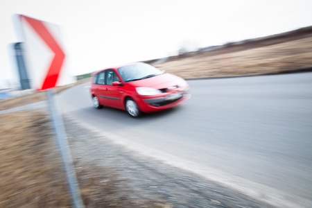Traffic concept  car driving fast through a sharp turn  motion blur is used to convey movement の写真素材