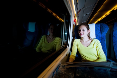 Young woman traveling by train at nightの写真素材