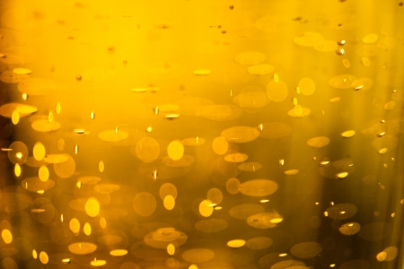 Golden macro background: gas bubbles in beer at shallow DOF against sunlight