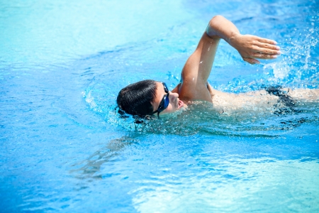 Young man swimming the front crawl in a poolの素材 [FY31014197094]