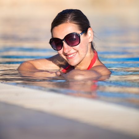 Portrait of a young woman relaxing in a swimming poolの写真素材