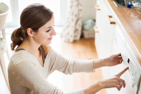 Housework: young woman putting dishes in the dishwasherの写真素材
