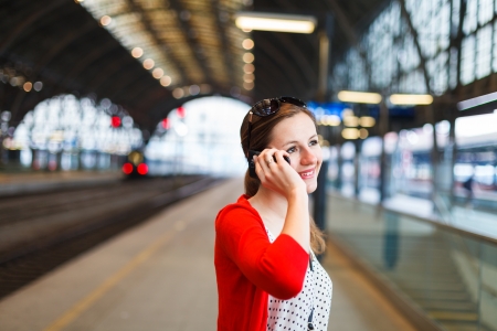 Pretty young woman at a train stationの写真素材