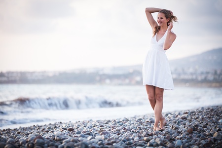 Young woman on the beach enjoying a warm summer eveningの写真素材