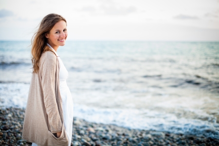 Young woman on the beach enjoying a warm summer eveningの写真素材