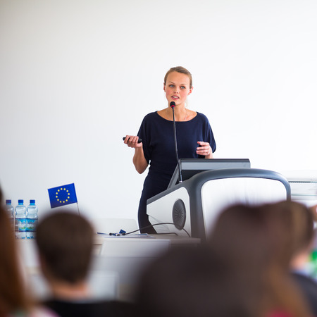 Pretty, young business woman giving a presentation in a conference/meeting setting 