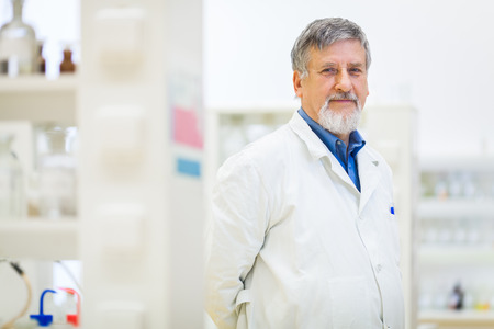 Senior male researcher carrying out scientific research in a lab (shallow DOF; color toned image)の写真素材