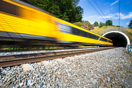 Fast train passing through a tunnel on a lovely summer day (motion blurred image)の写真素材