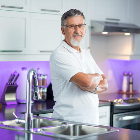 Senior man standing in his renovated, modern kitchen,の写真素材