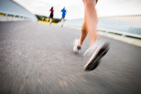 Young woman jogging outdoors (motion blurred image)の写真素材