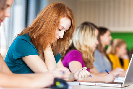 Students in a classroom during class (color toned image; shallow DOF)の写真素材