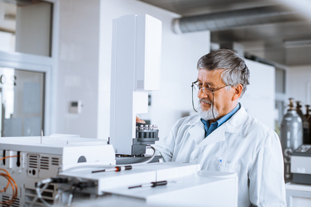 Senior male researcher carrying out scientific research in a lab (shallow DOF; color toned image)