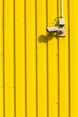 Security camera on a yellow wallの写真素材