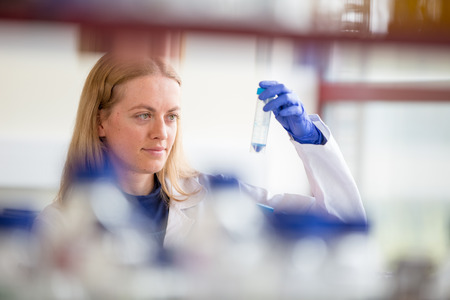 Portrait of a female researcher doing research in a lab (shallow DOF; color toned image)
