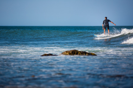 Young boy surfing the wave in a sunny day