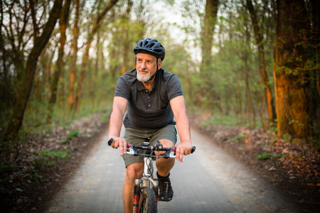 Senior man on his mountain bike outdoors (shallow DOF; color toned image)