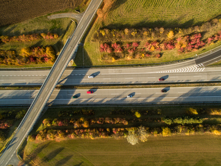 Aerial view of a highway amid fields with cars on it
