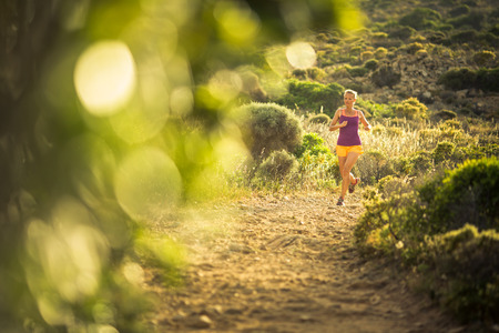Young woman running outdoors on a lovely sunny dayの写真素材