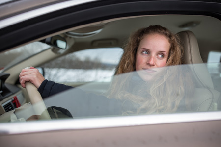 Pretty young woman driving her new car