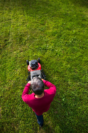 Senior man mowing the lawn in his gardenの写真素材