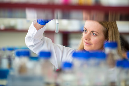 Portrait of a female researcher doing research in a lab (shallow DOF; color toned image)の写真素材