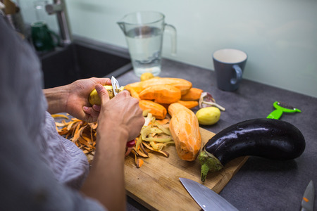 Young woman cooking in her modern kitchen (shallow DOF; color toned image)の写真素材