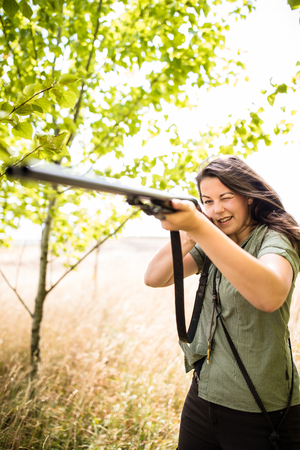 Autumn hunting season. Hunting. Outdoor sports. Woman hunter in the woodsの写真素材