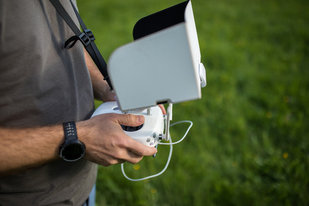 Man Operating a Drone by a Remote Control outdoors