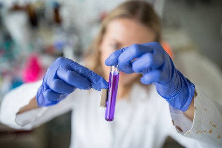 Female researcher carrying out scientific research in a lab (shallow DOF; color toned image)