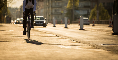 Bikers on a city street in warm evening sunlightの写真素材