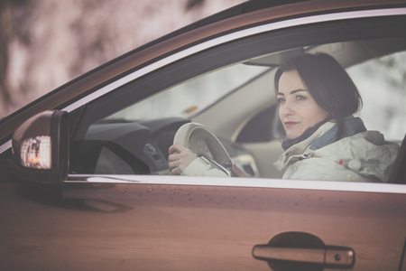 Pretty, young woman  driving a car -Invitation to travel. Car rental or vacation.の写真素材