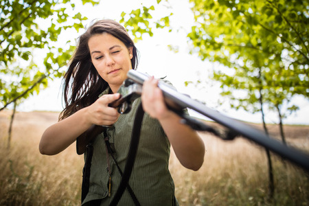 Autumn hunting season. Hunting. Outdoor sports. Woman hunter in the woodsの写真素材
