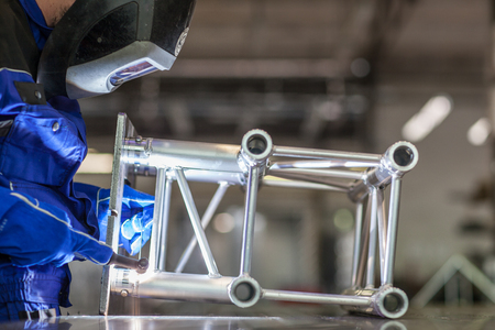 Industrial workers welding metal with many sharp sparks, Welder working a welding metal with protective mask and sparksの写真素材