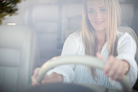 Pretty, young woman  driving a car -Invitation to travel. Car rental or vacation.