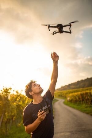 Young man flying a drone in warm evening sunlight
