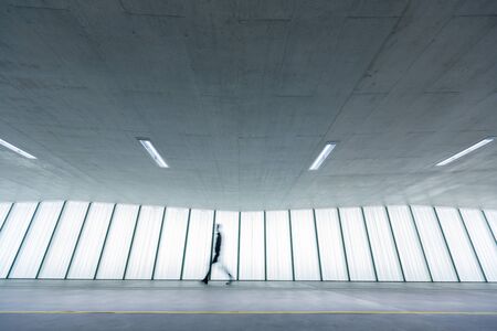 Motion blurred people - figures in an underpassage getting to their workplace in the morning. Busy...