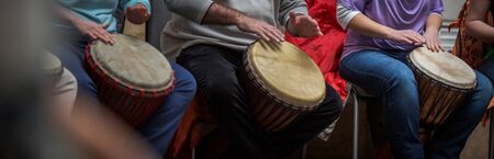Group of people playing on drums - therapy by music