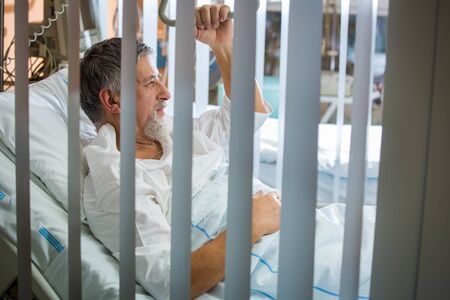 Senior male patient in a modern hospital (shallow DOF; color toned image)の写真素材