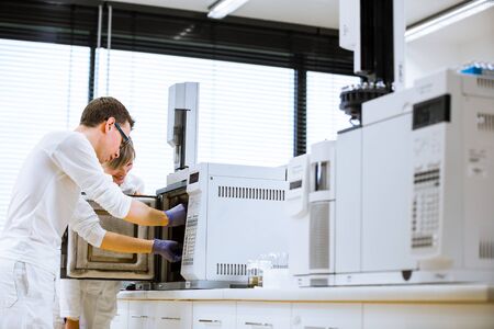 senior male researcher carrying out scientific research in a lab using a gas chromatograph (shallow DOF; color toned image)の写真素材