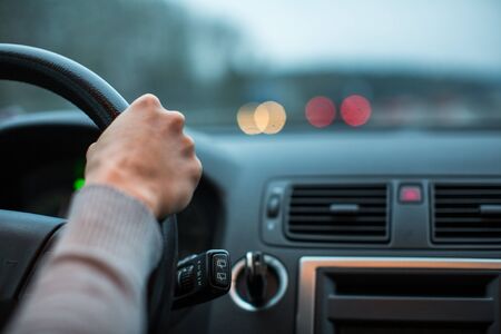 Driver's hands driving a car on a highway (color toned image; shallow DOF)
