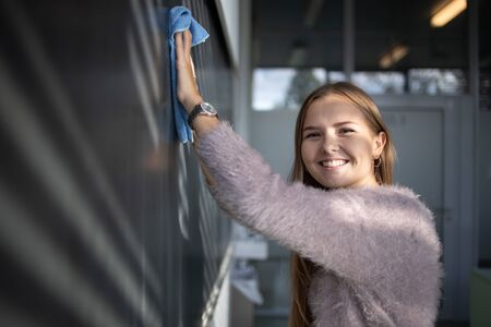 Pretty, young female student in front of a blackboard during math classの写真素材