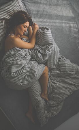 Pretty, young woman in her bed, fast asleep. Importance of sleep conceptの写真素材
