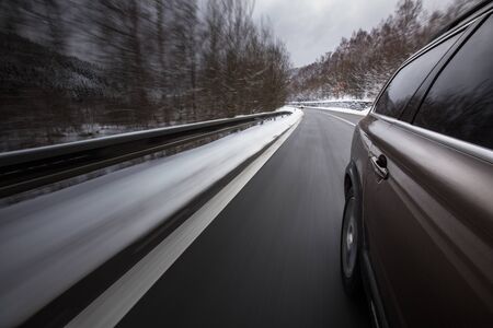 Fast moving car on a winter alpine snowy road