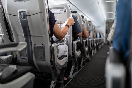 Interior of commercial airplane with passengers in their seats during flight.