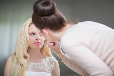 Beautiful bride with fashion wedding hairstyle. Closeup portrait of young gorgeous bride. Wedding Studio shot (color toned image; shallow DOF)の写真素材