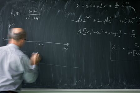 Math teacher drawing   fuction graph on a blackboard during mathclass (motion blurred image)